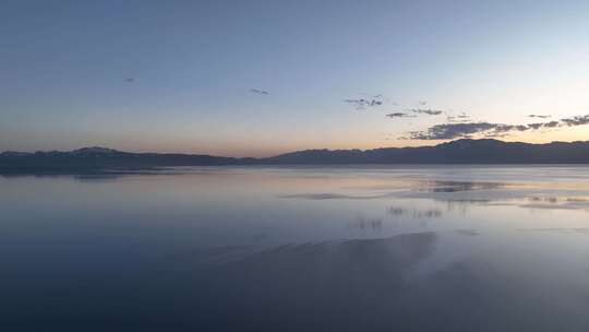 赛里木湖风平浪静的湖面倒映着美丽的朝霞