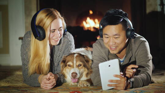 夫妇和狗一起在壁炉前看平板视频素材模板下载