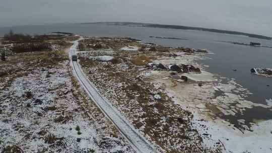 黑色货车在湖天线附近积雪覆盖的道路上行驶