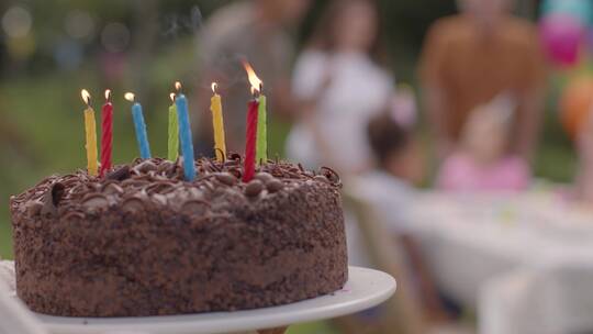 一个蛋糕被带到生日派对桌子上后的跟踪镜头