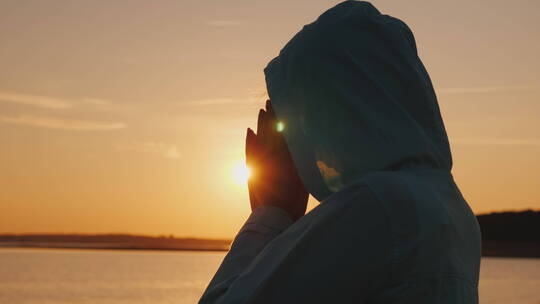中年妇女在湖边祈祷视频素材模板下载