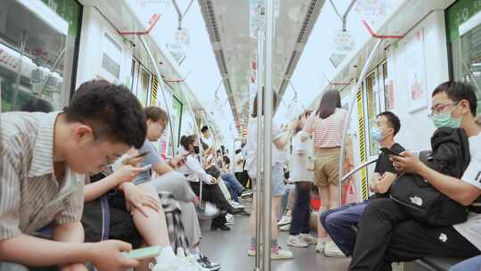 地铁上使用手机的人们