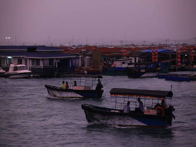 海南岛渔港清晨 渔船驶过蛋民船屋