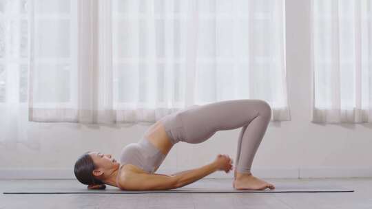 女人练习瑜伽半桥姿势视频素材模板下载