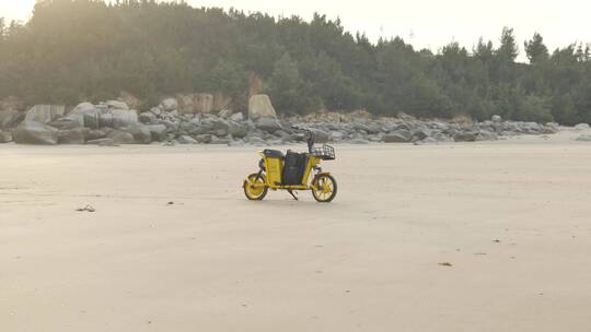 海边沙滩上停泊的共享单车