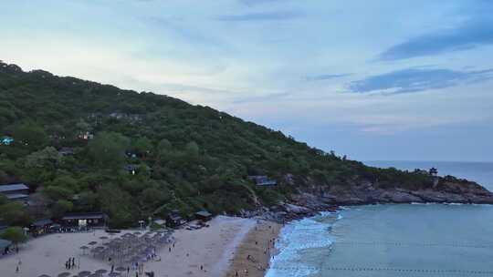 海岸边绿意盎然的山景与平静海面