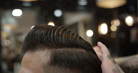 理发师在理发店用梳子梳理客户的头发
