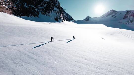 徒步旅行者在雪山脚下行走