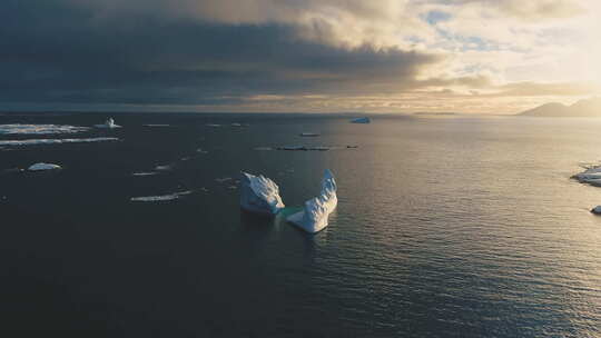 南极洲上空日落时的雪山。正面空中跟踪视图