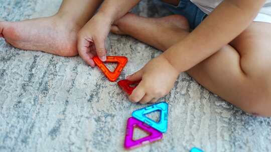 小女孩在家玩彩色磁铁塑料块