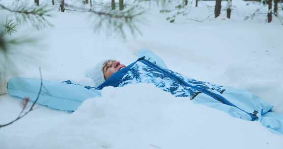 一个年长快乐的女人躺在雪地里，变成了雪天