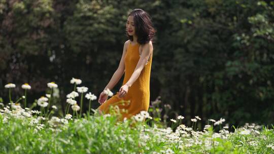 短裙美女走在开满鲜花的夏天森林草地