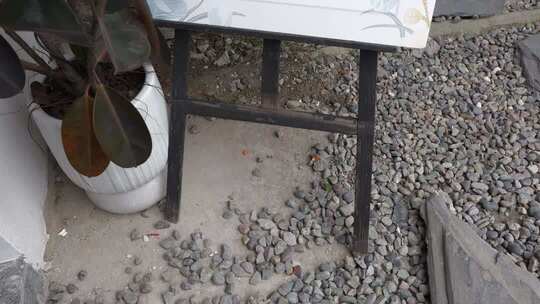 户外碎石地面上的桌子与盆栽