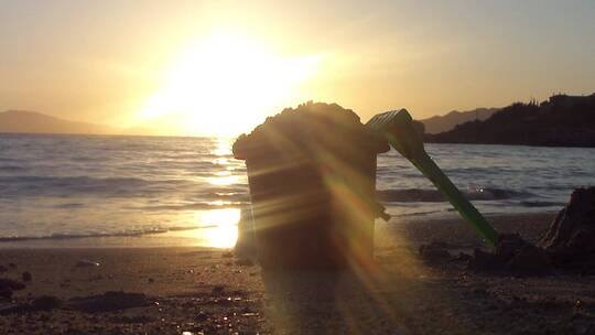 沙滩海岸夕阳余晖儿童挖沙子工具视频素材模板下载
