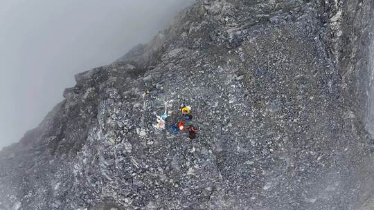 航拍登顶岷山山脉主峰雪宝顶雪山的登山者