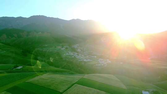 夕阳落日下山谷里的村庄田野航拍