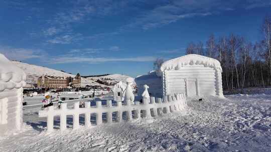 雪地中的雪雕小屋和动物造型