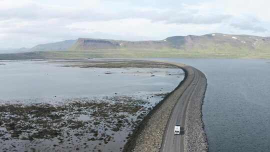 冰岛西峡湾水景中公路上行驶的车辆鸟瞰图。视频素材模板下载