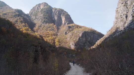 男子走在秋天的山间小路上