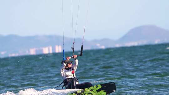 刮风的日子里，运动员在海滩上练习风筝冲浪