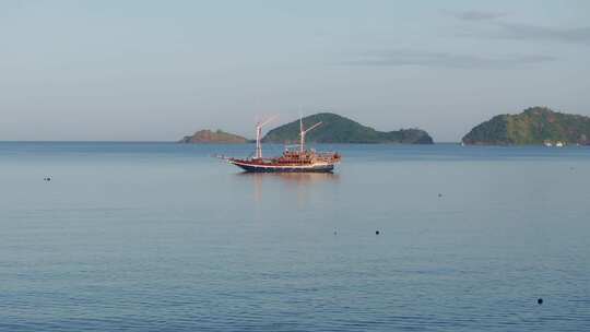 印度尼西亚科莫多岛日出时充满帆船的港口鸟