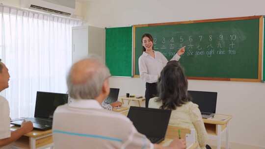 亚洲女教师在语言学校教成熟的学生。