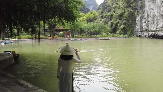 一个戴帽子的女人站在水里