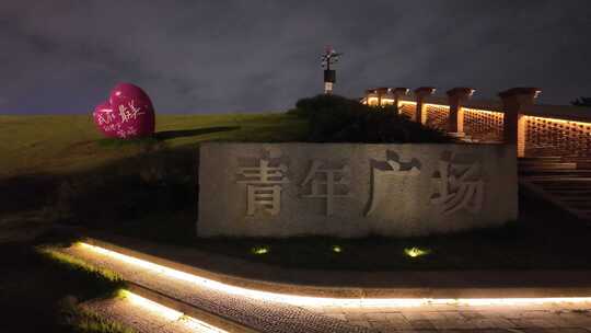 青年广场夜景，标志性石碑与爱心雕塑