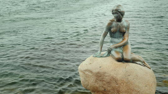 哥本哈根著名地标雨天的小美人鱼雕像