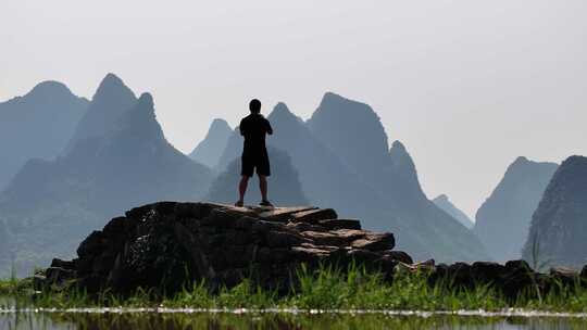 男子站在岩石上赏喀斯特地貌风景