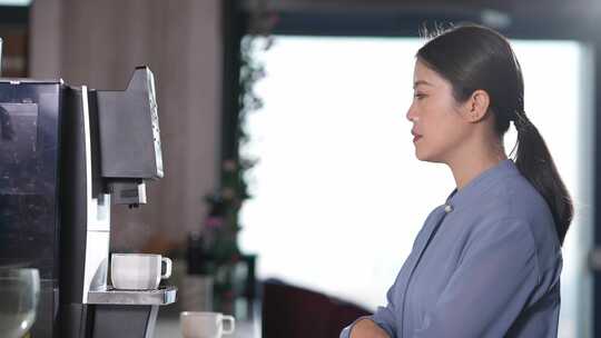 职业女性在办公室咖啡机前泡咖啡