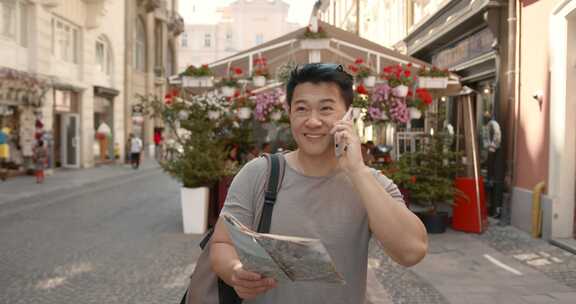 拿着地图的韩国人在城市里打电话