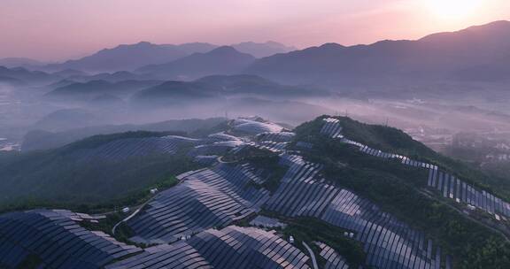 新能源太阳能光伏发电站夕阳下山坡航拍