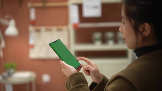 女性使用绿色绿幕抠像替换屏幕手机