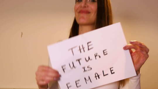 女人拿着一张白纸，上面写着“未来是女性”