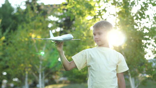 小男孩拿着飞机模型玩耍