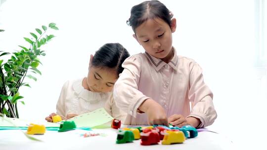 两名认真玩剪纸游戏的中国女孩视频素材模板下载