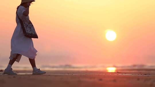 烟台夏天海边落日夕阳，女孩在沙滩上走动