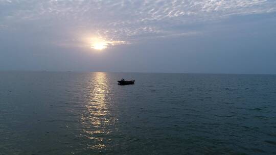 落日余晖渔船海面后飞