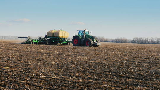 拖拉机带着播种机在田里播种小麦
