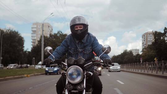 穿着蓝色牛仔夹克的男人骑着他的摩托车视频素材模板下载