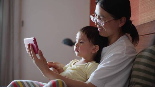 小女孩和妈妈在一起看手机动画片亲子母婴