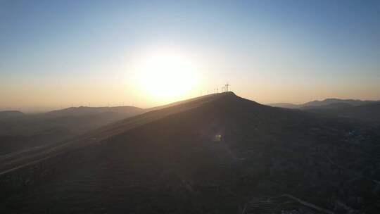 风力发电大风车山坡城镇落日余晖环视