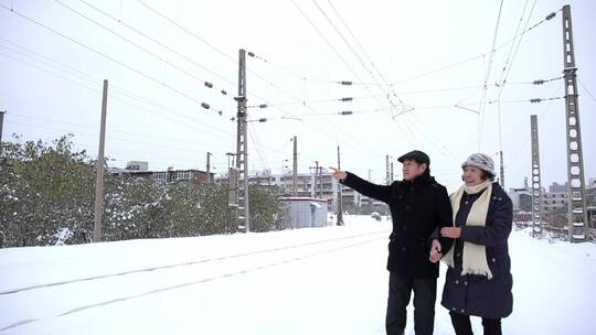 退休生活老年夫妻雪天外出散步赏景恩爱幸福