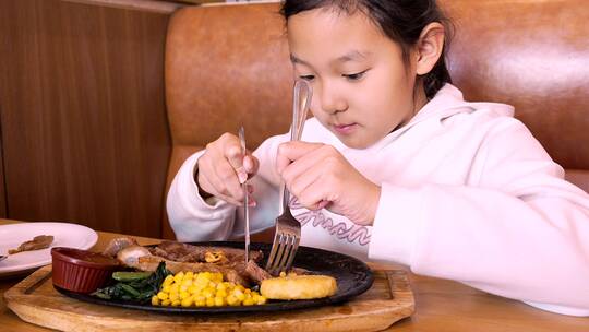 4K升格实拍堂食在西餐厅切牛排的亚洲女孩