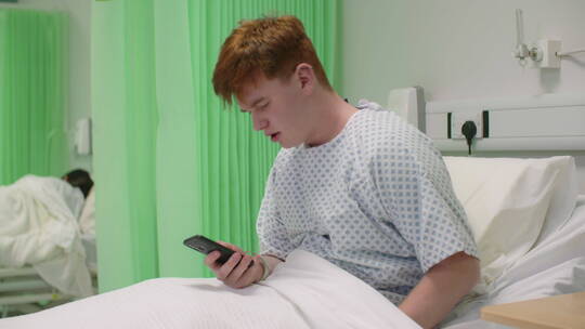 病人坐在病床上看手机