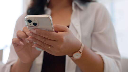 女性手中的智能手机，滚动社交媒体和通信技