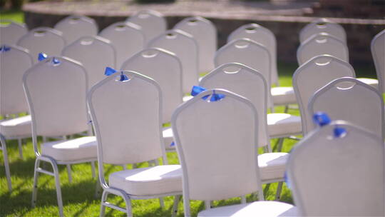 草坪婚礼仪式上空白色椅子的平移镜头