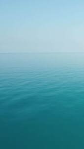 鸟瞰平静蔚蓝大海的垂直视图水面上的小波浪