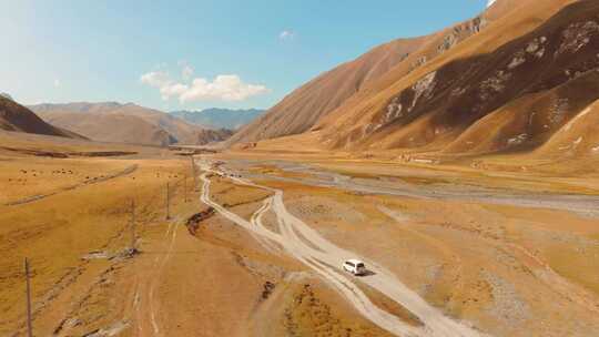 三菱Delica旅游车在卡兹贝吉的Dusty Road上行驶视频素材模板下载